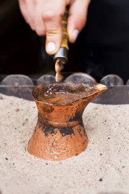 Kafe barda kum içinde Türk kahvesi hazırlanması. Seçici odak.
