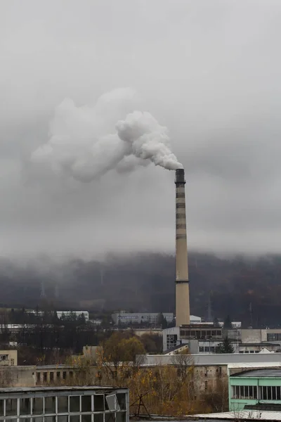 Atmospheric air pollution from Industrial chimney smoke in cloudy rainy day.