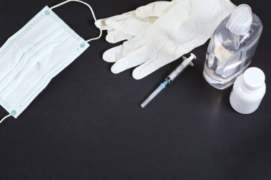 Yüz maskesi, hijyenik eldivenler, spiritüs, el dezenfektanı virüsü ve veba enfeksiyonunu önlemek, siyah arka planda covid-19 virüsünü önlemek..