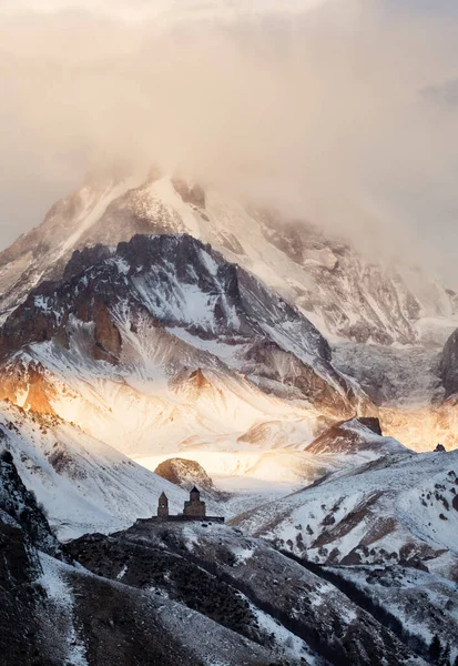 Gergeti Trinity Church, Holy Trinity Church and mount Kazbek 5,054 m high, near the village of Gergeti in Georgia.