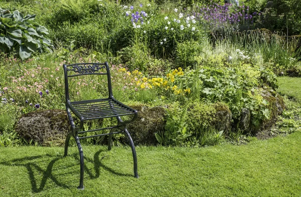 Jardim com cadeira de metal verde como decoração — Fotografia de Stock