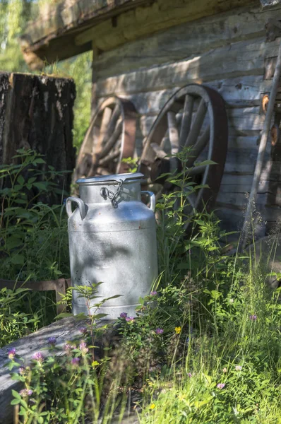 Alte Milchzirpen vor altem Haus — Stockfoto