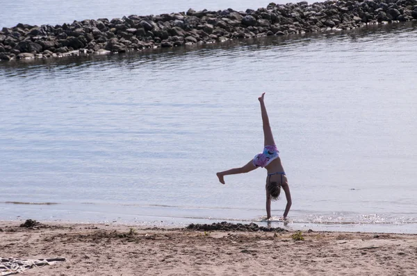 Девушка занимается гимнастикой на пляже — стоковое фото