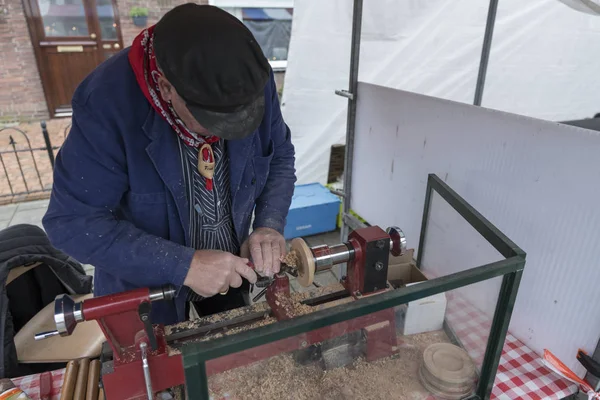 Mann dreht Holzkerze steht auf Holzdrehbank — Stockfoto