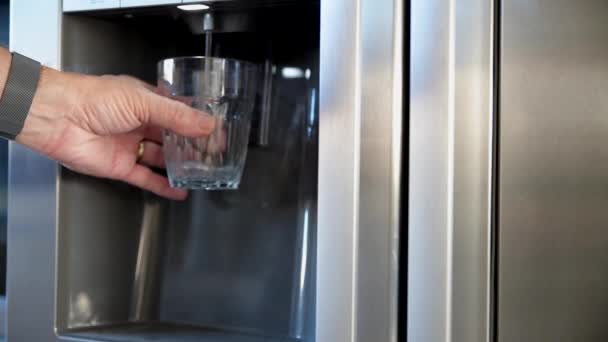 Man die gekoeld water uit de koelkast haalt — Stockvideo
