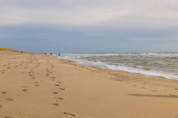 Människor går på stranden under hård vind — Stockfoto