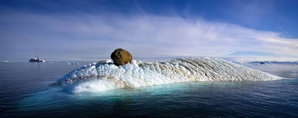 Isberg i vattnet med båt — Stockfoto