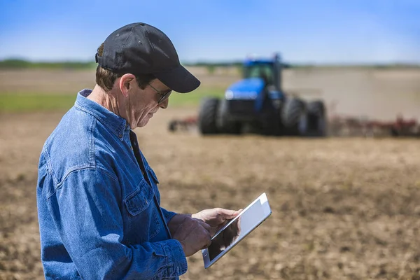 Landwirt Mit Einer Tablette Während Auf Einem Feld Steht Traktor — Stockfoto