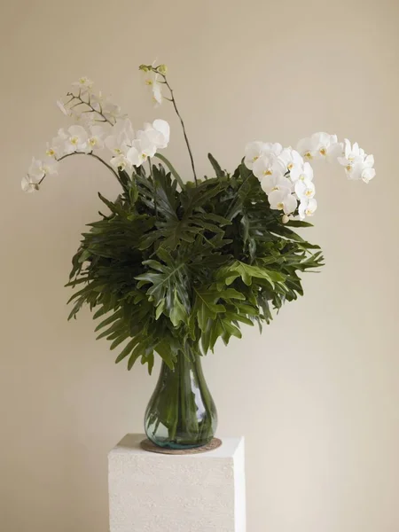 Florero con vegetación y flores - foto de stock