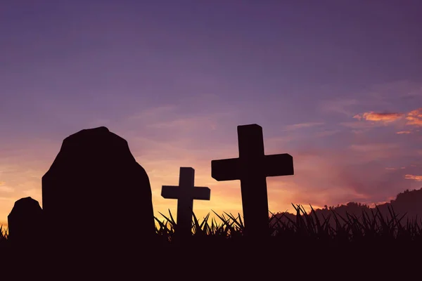 A pedra tumular e silhueta crucifixo, com um céu laranja iluminado — Fotografia de Stock