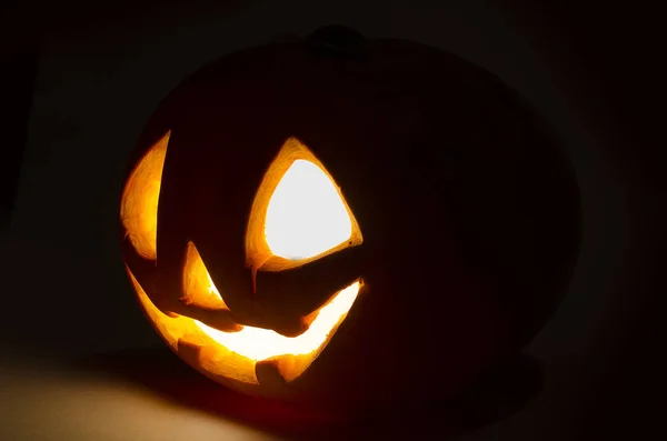 Gruselig lächelnder Halloween-Kürbis auf dunklem Hintergrund — Stockfoto