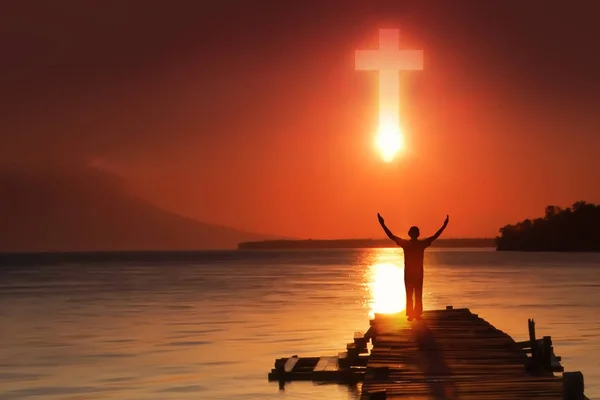 Silhouette of Christian prayers raising hand while praying to the Jesus