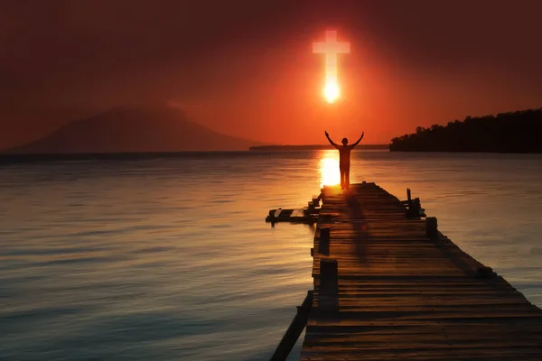 Hristiyan dualarının silueti İsa 'ya dua ederken el kaldırıyor.