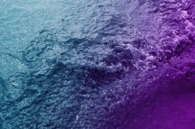 Mavi ve mor renkte filtrelenmiş deniz dalgası yüzeyi arkaplan için kullanılabilir 