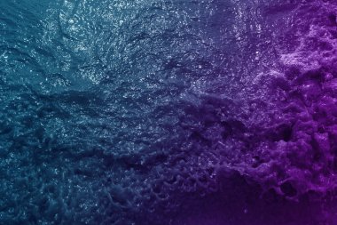 Mavi ve mor renkte filtrelenmiş deniz dalgası yüzeyi arkaplan için kullanılabilir 