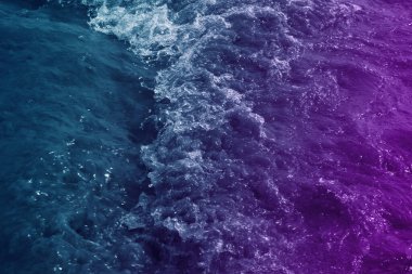 Mavi ve mor renkte filtrelenmiş deniz dalgası yüzeyi arkaplan için kullanılabilir 