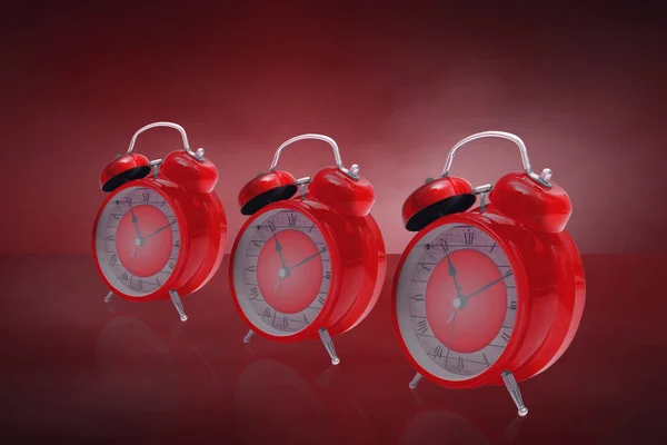 Tre Röda Väckarklockor Ett Glasbord Med Röd Bakgrund — Stockfoto