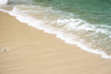 Dalgalar kayalıklara çarpıyor, yukarıdan görünüyor.