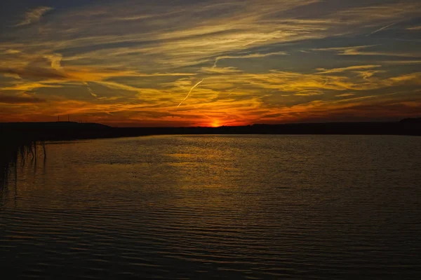 Der Sonnenuntergang spiegelt sich im Wasser des Flusses wider. — Stockfoto