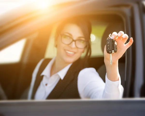 Счастливая улыбающаяся молодая женщина с ключом от машины — стоковое фото