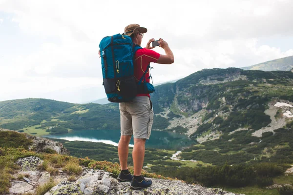 Turista com câmera nas montanhas — Fotografia de Stock