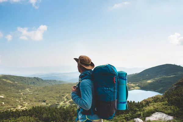Sırt çantalı genç adam dağda — Stok fotoğraf