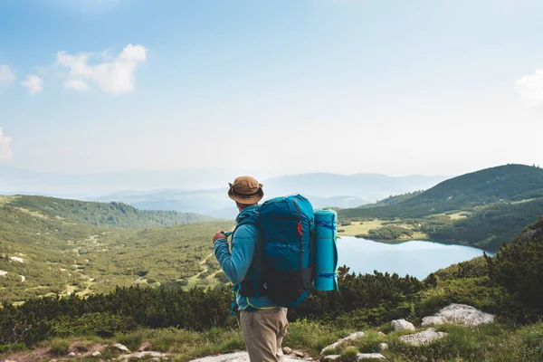 Jeune homme avec sac à dos dans la montagne — Photo