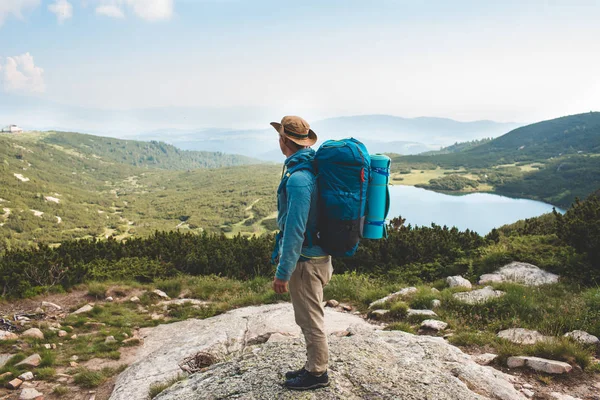 Sırt çantalı genç adam dağda — Stok fotoğraf