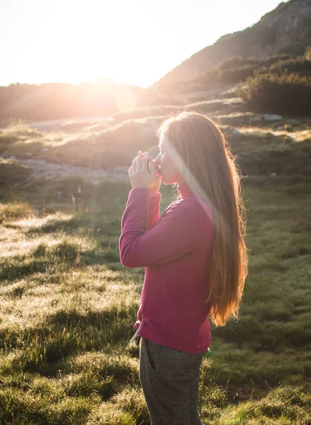 Jonge vrouw drinken van thee op de berg — Stockfoto