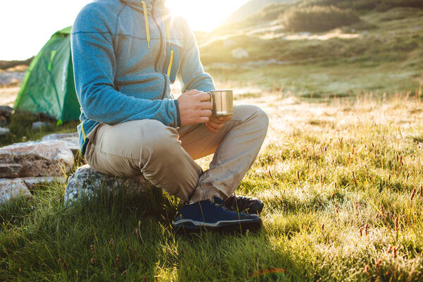 Young man drinking tea at the mountain