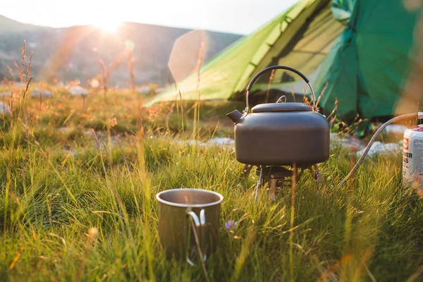 Camping czajnik i cap na trawie — Zdjęcie stockowe