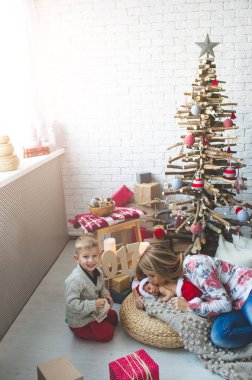 Genç kadın ve moda xmas ağacı yakınındaki yavruları