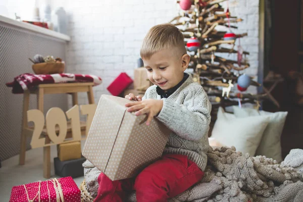 Garoto sorridente perto da árvore de xmas da moda — Fotografia de Stock