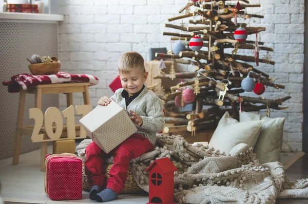 Garoto sorridente perto da árvore de xmas da moda — Fotografia de Stock