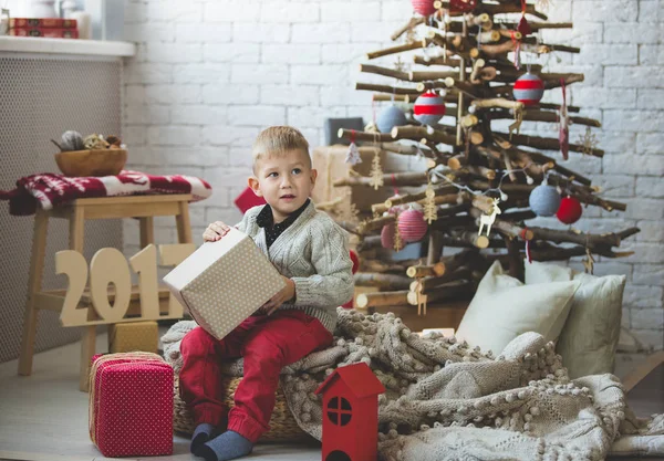 Garoto sorridente perto da árvore de xmas da moda — Fotografia de Stock