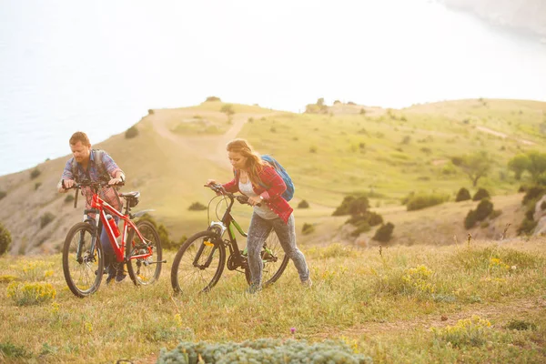 Ungt par ridning cyklar i bergen — Stockfoto