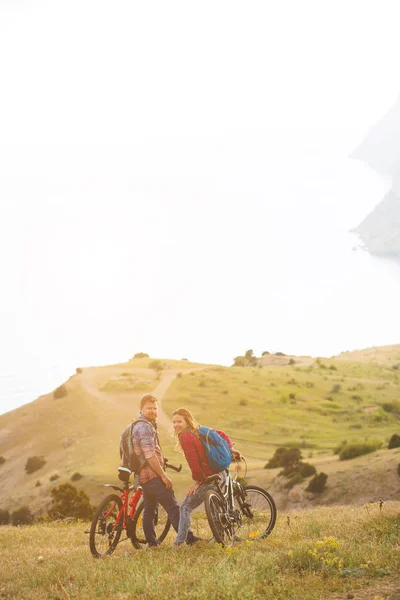 Pareja joven montando bicicletas en las montañas — Foto de Stock