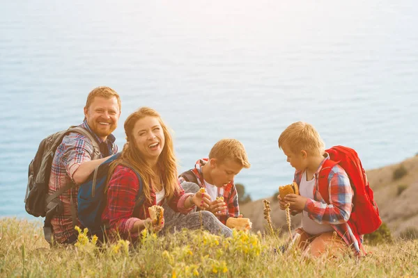Familj på fyra personer äta fastfood i bergen — Stockfoto