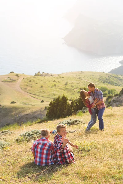 Familia de cuatro personas que buscan hermosos paisajes marinos en las montañas — Foto de Stock