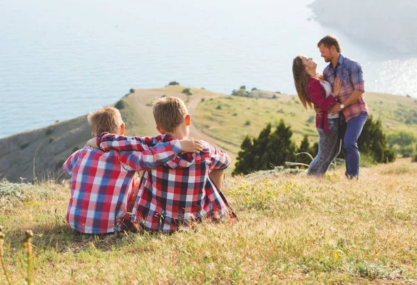 Family of four people looking to beautiful seascape in mountains — Stock Photo, Image
