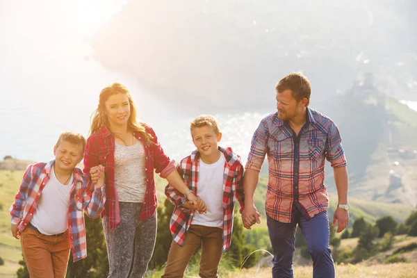 Familia de cuatro personas que buscan hermosos paisajes marinos en las montañas — Foto de Stock