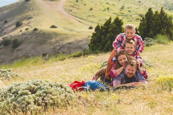 Familia de cuatro personas que buscan hermosos paisajes marinos en las montañas — Foto de Stock