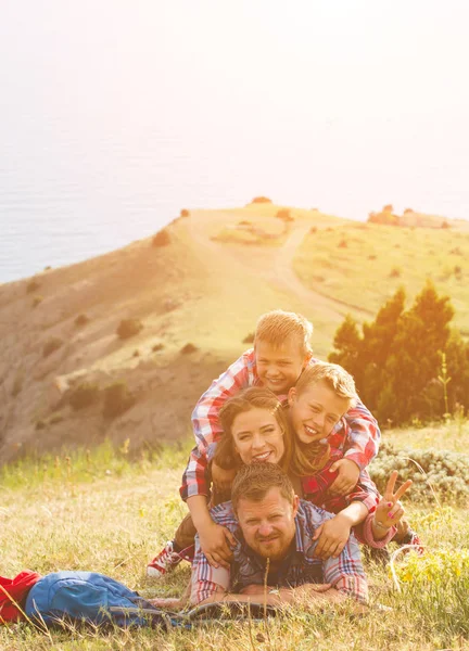 Vierköpfige Familie mit Blick auf das Meer in den Bergen — Stockfoto