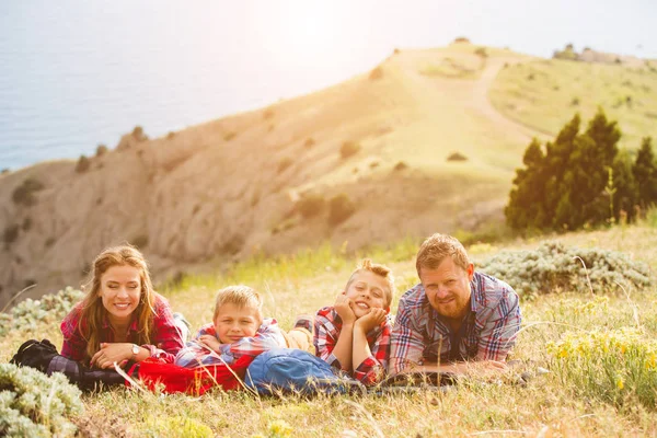 Familia de cuatro personas que buscan hermosos paisajes marinos en las montañas — Foto de Stock