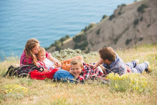 Vierköpfige Familie mit Blick auf das Meer in den Bergen — Stockfoto