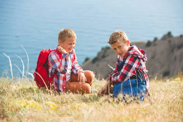 Dos hermanos caminando en las montañas cerca del mar —  Fotos de Stock