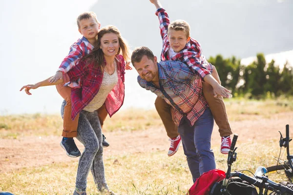 Family of four people riding bikes in the mountains