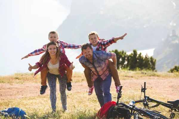 Familia de cuatro personas montando bicicletas en las montañas — Foto de Stock