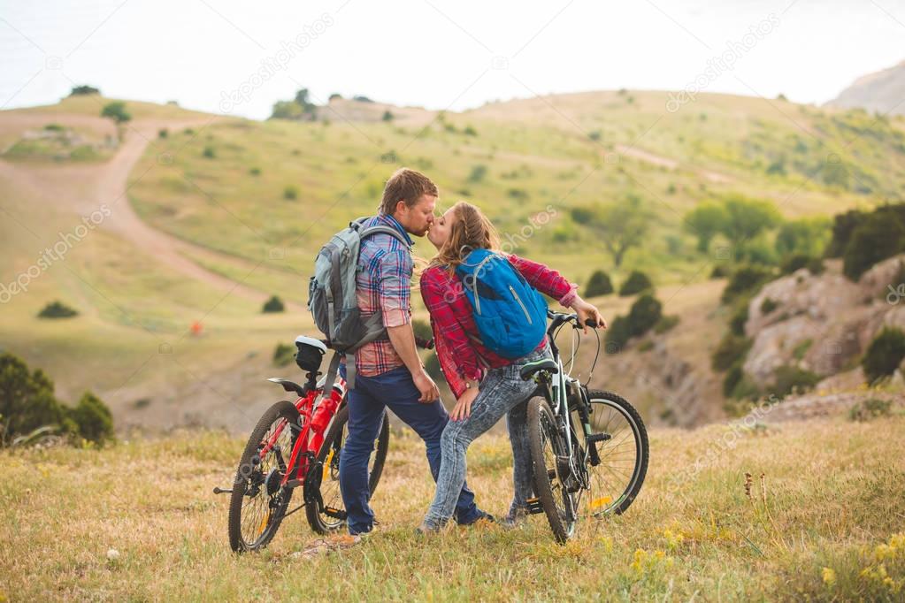 young couple  riding bikes in the mountains