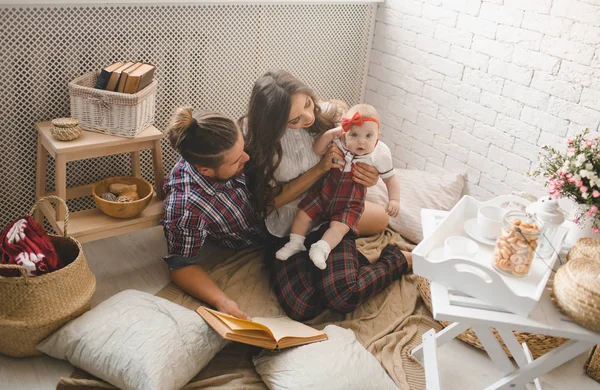 Молодая семья читает сказки в помещении — стоковое фото